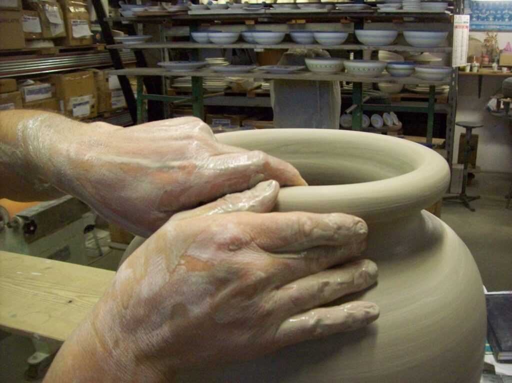The potter Piero Borgioli is shaping a standumbrella in his workshop