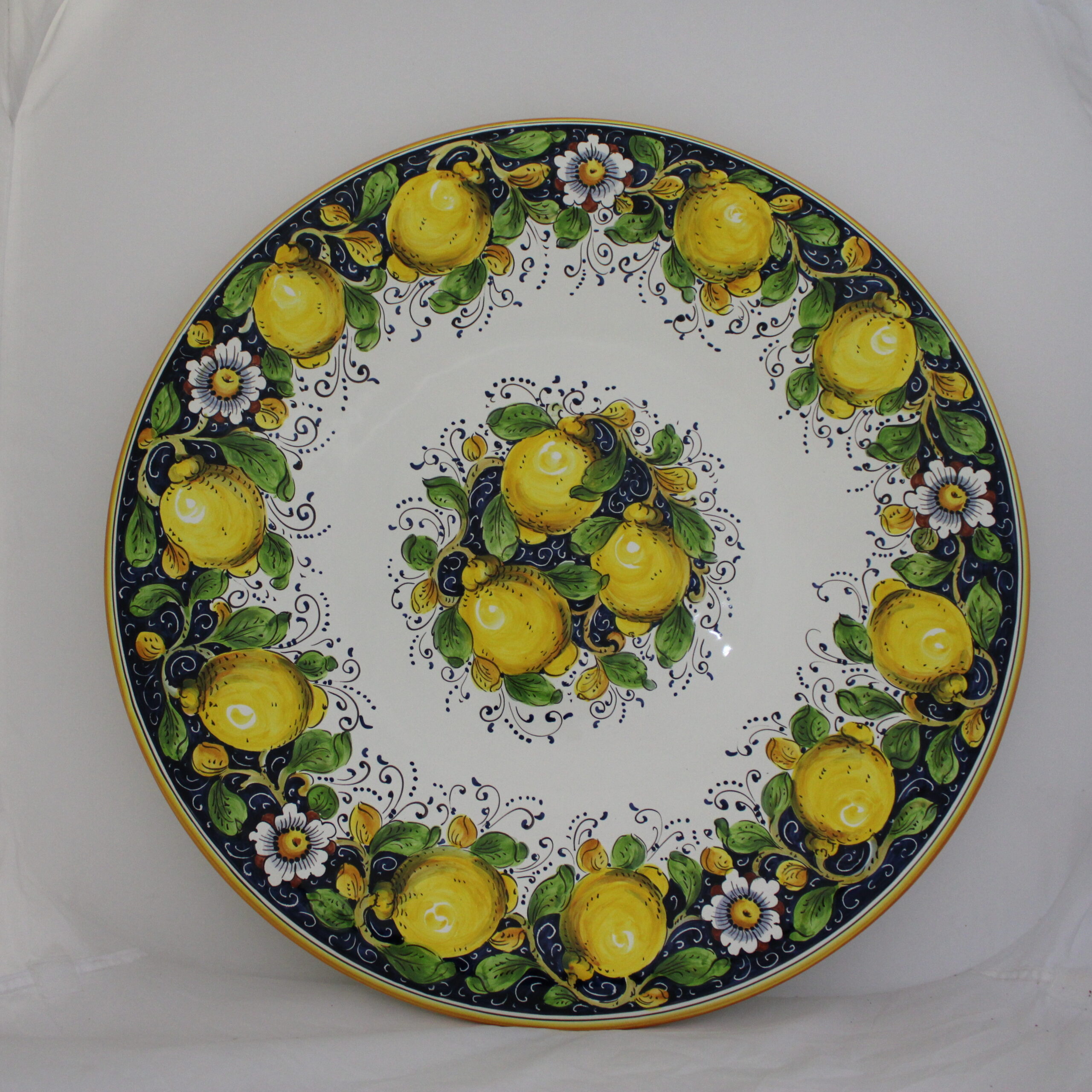 Wall and serving plate hand painted. Beautiful yellow lemons on blue background with white flowers and green and orange leaves.