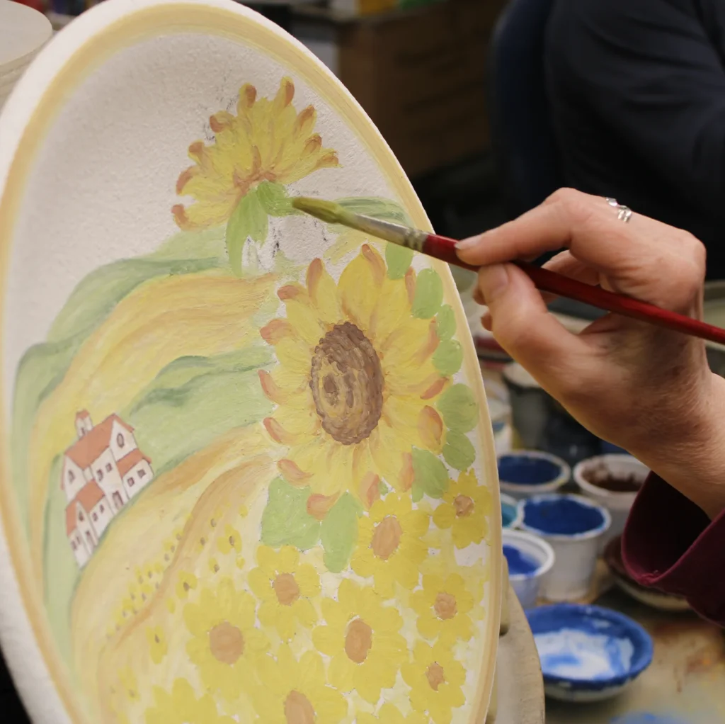Ceramiche Borgioli' s painter is creating a tuscan landscape with sunflowers